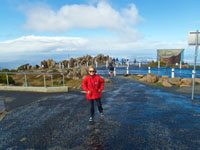 Photo of Susan at the top of Mt Wellington in Tasmania with Hobart in the background in the snow when she is mountain biking